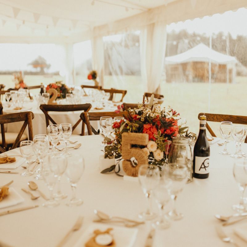 Rust coloured wedding flowers at marquee wedding with bride wearing Eliza Jane Howell wedding dress
