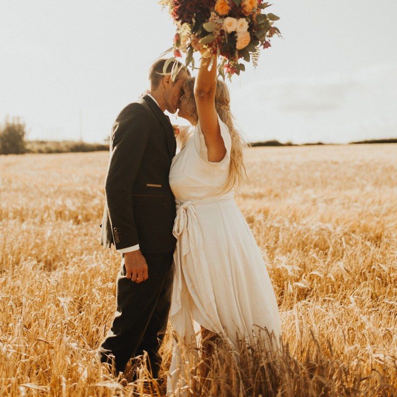 Bride changes from Eliza Jane Howell dress to Ghost wedding dress clutching rustic bouquet