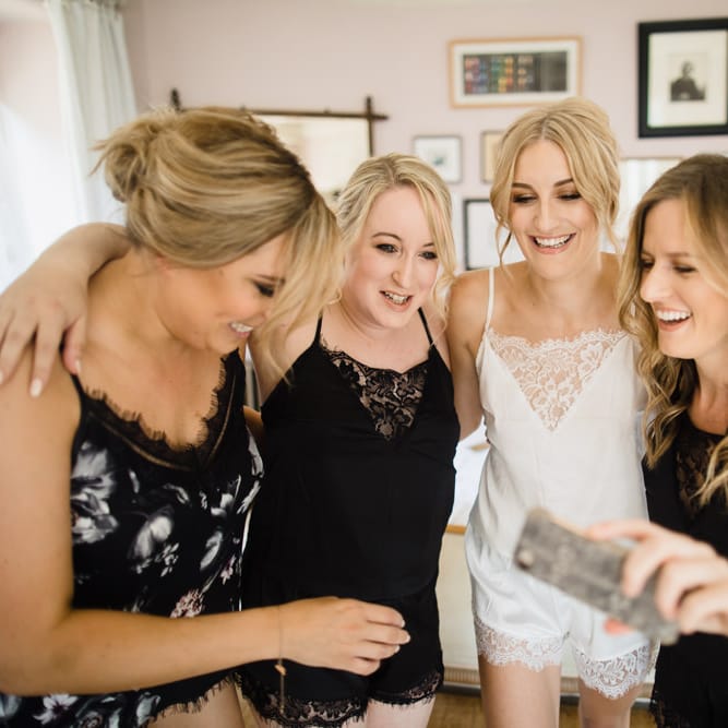 Bridal Party Morning Preparations | Bride in White Lace Pyjamas | Ivania Pronovias Wedding Dress with Long Sleeves and Minimalist Styling | Chris Barber Photography