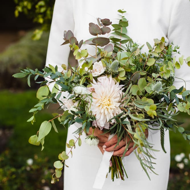 Bridal Bouquet of Scabious, Ammi Majus, Veronica, Snowberries, Chocolate Cosmos, Black Scabious, Cafe au Lait Dahlias and Majolica Spray Roses with White Trailing Ribbon | Bride in Long Sleeved Wedding Dress with Plunging V Back and Cuff Buttons by Pronovias | Ivania Pronovias Wedding Dress with Long Sleeves and Minimalist Styling | Chris Barber Photography