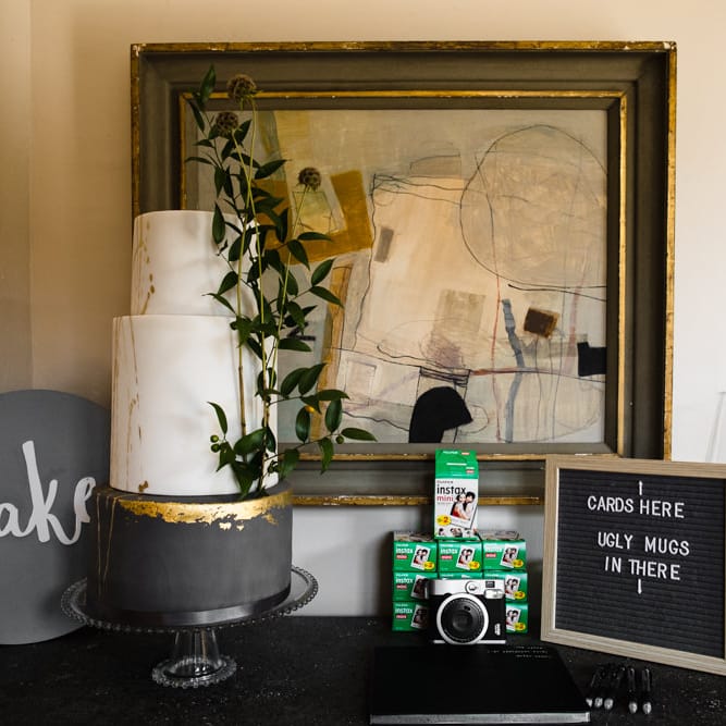 Three Tier Wedding Cake with White and Grey Icing, Gold Leaf Detail and Grey Ribbon | Polaroid Photobooth | Ivania Pronovias Wedding Dress with Long Sleeves and Minimalist Styling | Chris Barber Photography