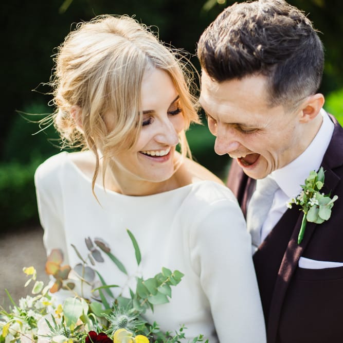 Bride in Long Sleeved Wedding Dress with Plunging V Back and Cuff Buttons by Pronovias | Groom in Black Three Piece Suit with Grey Tie and Personalised Tie Clip | Bridal Bouquet of Scabious, Ammi Majus, Veronica, Snowberries, Chocolate Cosmos, Black Scabious, Cafe au Lait Dahlias and Majolica Spray Roses with White Trailing Ribbon | Bridal Up Do | Ivania Pronovias Wedding Dress with Long Sleeves and Minimalist Styling | Chris Barber Photography