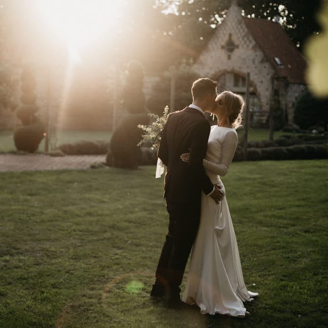 Bride in Long Sleeved Wedding Dress with Plunging V Back and Cuff Buttons by Pronovias | Groom in Black Three Piece Suit with Grey Tie and Personalised Tie Clip | Bridal Bouquet of Scabious, Ammi Majus, Veronica, Snowberries, Chocolate Cosmos, Black Scabious, Cafe au Lait Dahlias and Majolica Spray Roses with White Trailing Ribbon | Bridal Up Do | Ivania Pronovias Wedding Dress with Long Sleeves and Minimalist Styling | Chris Barber Photography