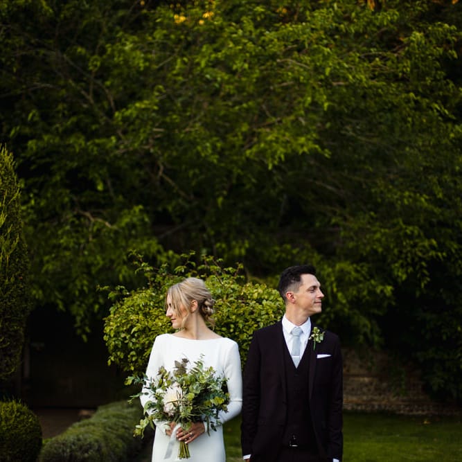 Bride in Long Sleeved Wedding Dress with Plunging V Back and Cuff Buttons by Pronovias | Groom in Black Three Piece Suit with Grey Tie and Personalised Tie Clip | Bridal Bouquet of Scabious, Ammi Majus, Veronica, Snowberries, Chocolate Cosmos, Black Scabious, Cafe au Lait Dahlias and Majolica Spray Roses with White Trailing Ribbon | Bridal Up Do | Ivania Pronovias Wedding Dress with Long Sleeves and Minimalist Styling | Chris Barber Photography
