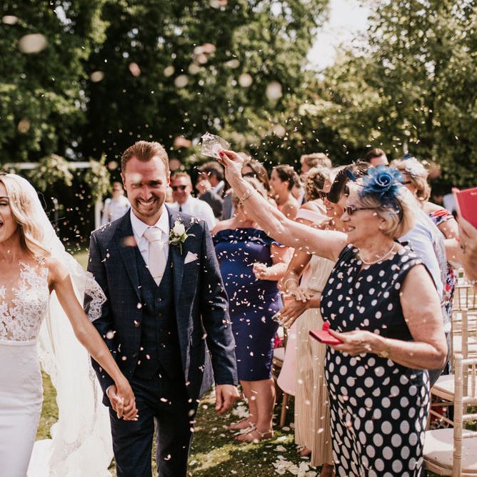 Confetti Moment with Bride in Pronovias Wedding Dress and Groom in Moss Bros. Suit
