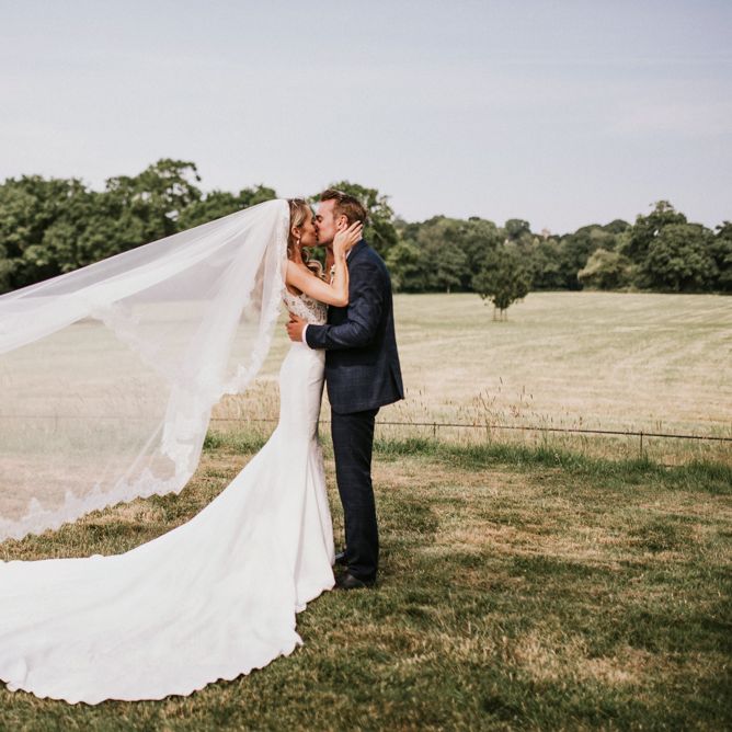 Bride in Vicenta Pronovias Wedding Dress and Groom in Navy Check Moss Bros Suit