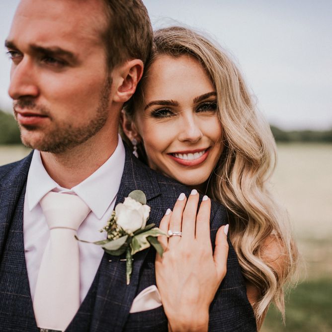 Beautiful Bride and Groom Embracing in Field