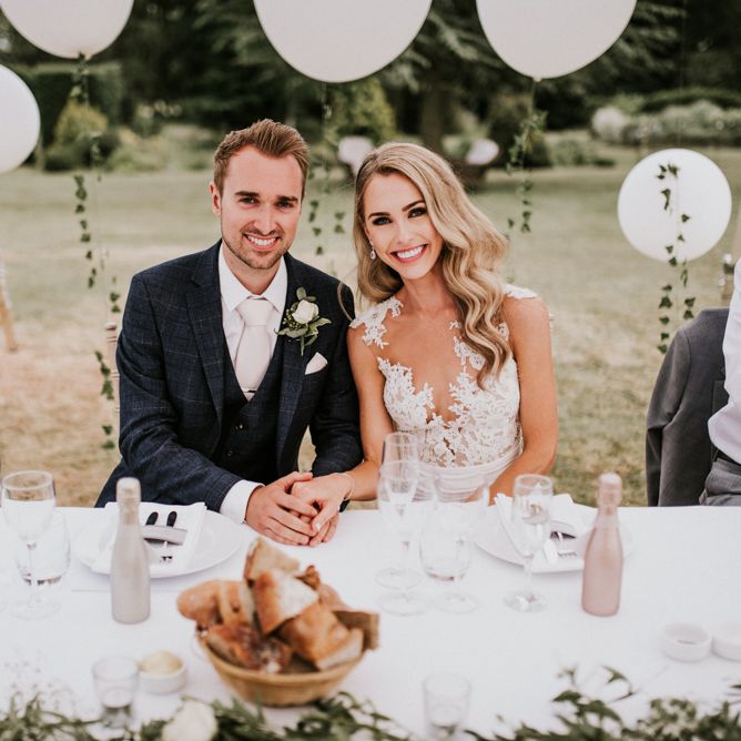 Bride in Vicenta Pronovias Wedding Dress and Groom in Navy Check Moss Bros Suit at Wedding Breakfast