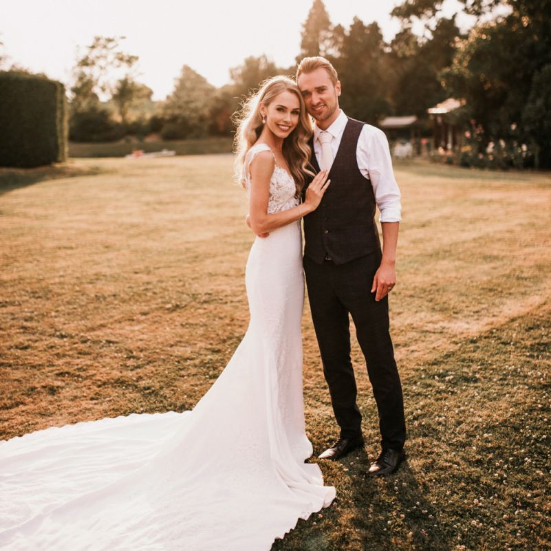 Golden Hour Portrait with Bride in Vicenta Pronovias Wedding Dress and Groom in Navy Check Moss Bros Suit