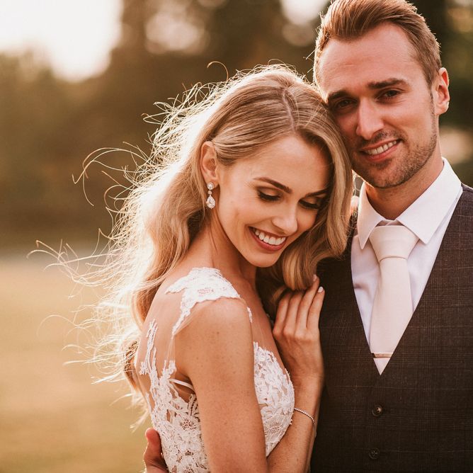 Sunset Portrait with Bride in Vicenta Pronovias Wedding Dress and Groom in Navy Check Moss Bros Suit