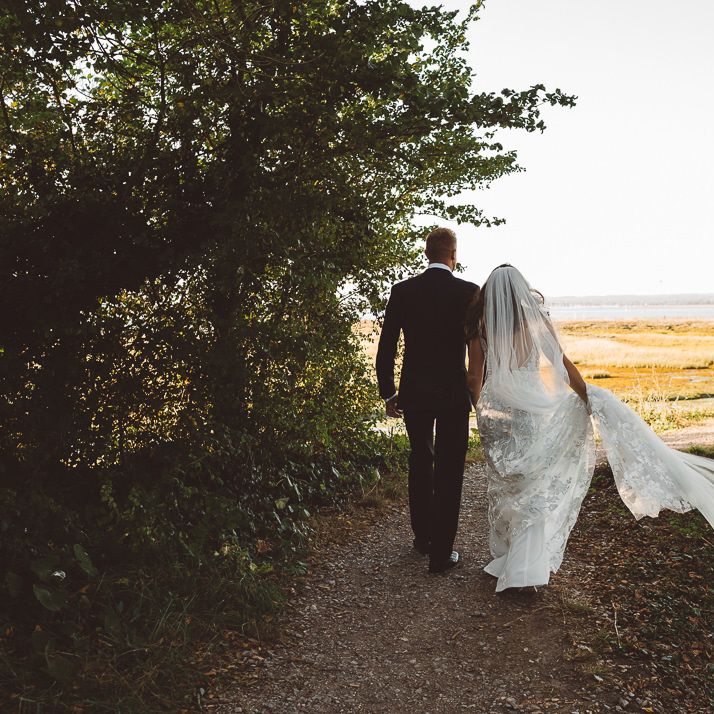 Back of brides Made With Love Bridal dress and veil at romantic outdoor wedding