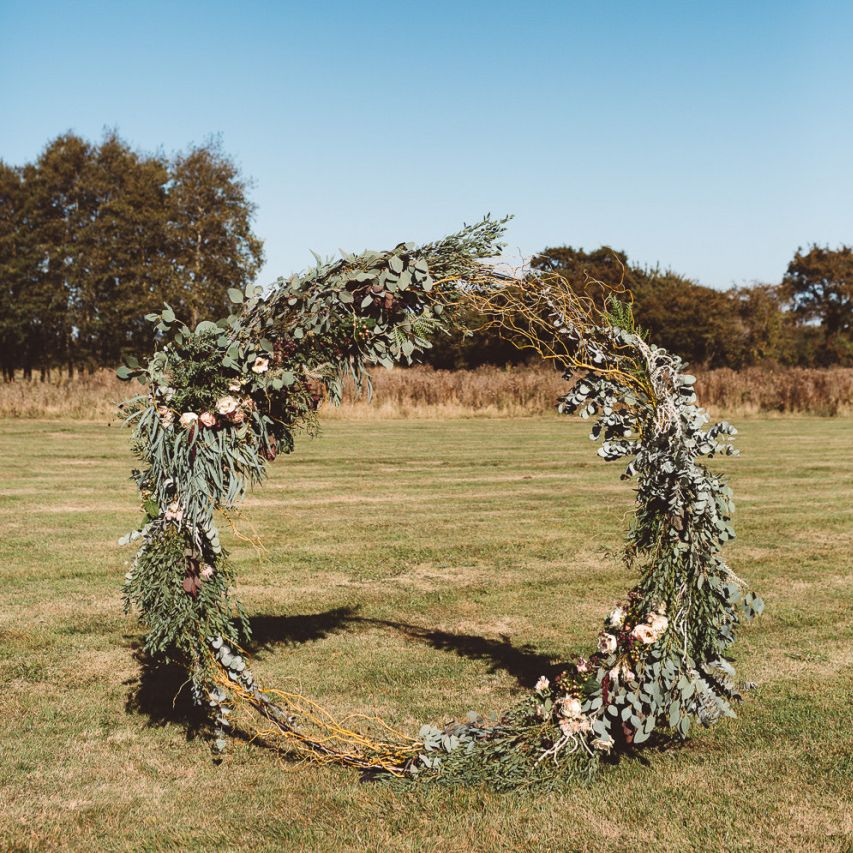 Aisle hoop decor styled with eucalyptus and foliage at Crouchers Orchards for outdoor ceremony