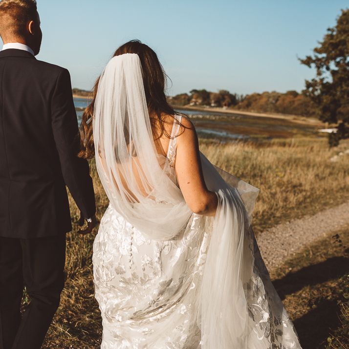 Back of brides Made With Love Bridal dress and veil at romantic outdoor wedding