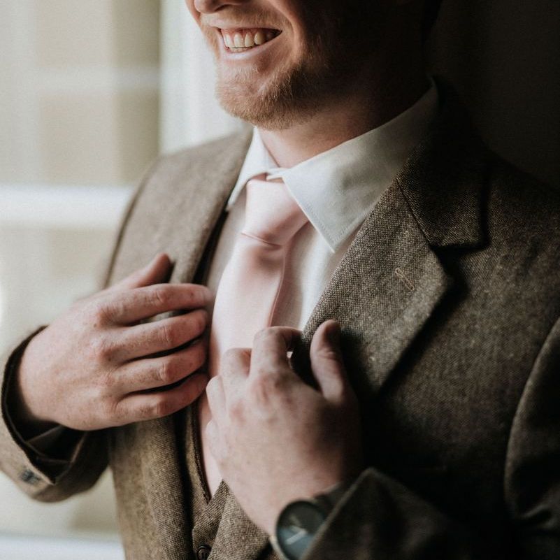 Groom preparations with tweed suit and pink tie