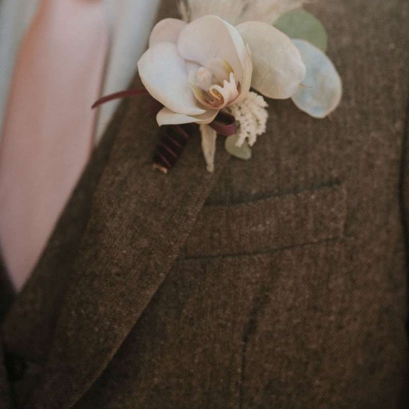 Wedding buttonhole to match orchid bouquet