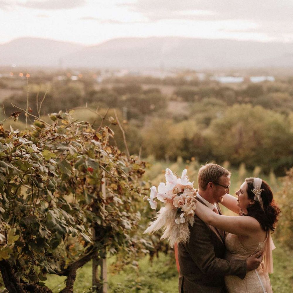 Groom in tweed wedding suit kisses