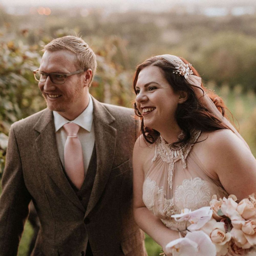 Bride holding orchid bouquet with groom at destination wedding in Italy