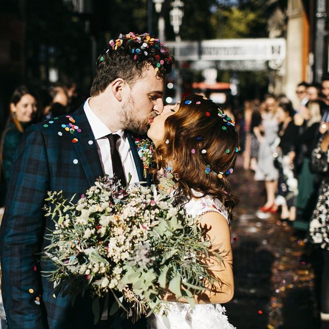 Bride and groom confetti shot at autumn celebration in London with green and white foliage bouquet