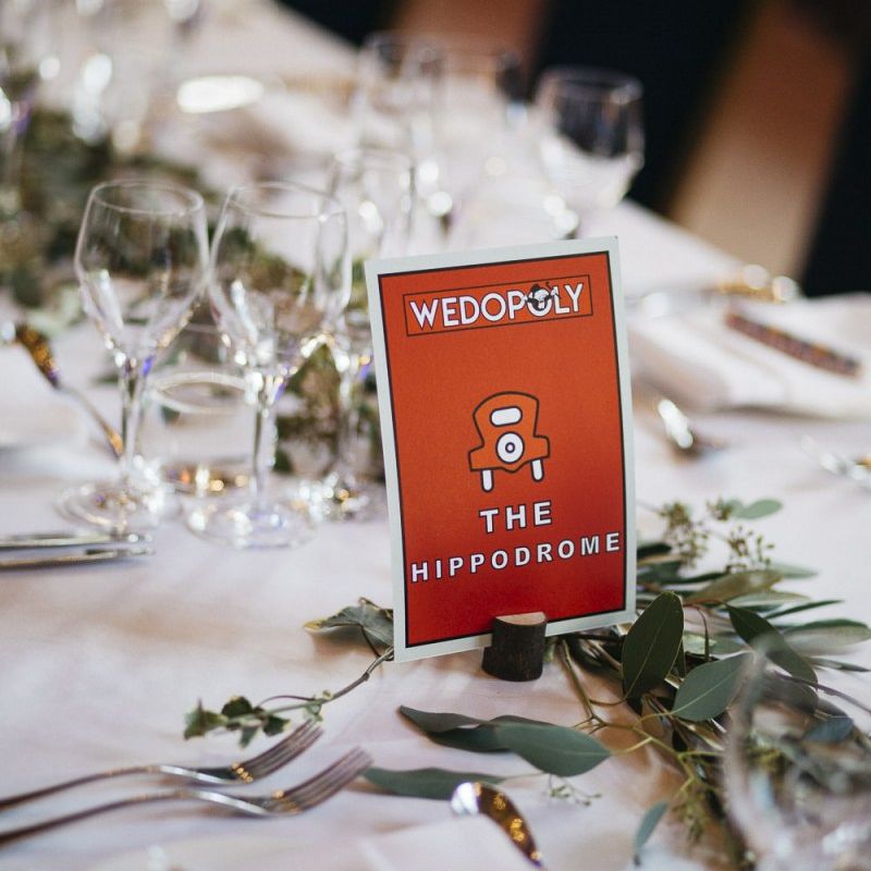 Monopoly style table setting names for London reception with foliage decor