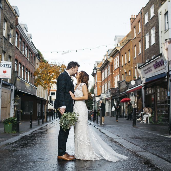 Bride and groom at London wedding with white foliage bouquet