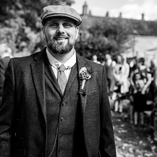 Wedding Ceremony | Groom in Burgundy Tweed Three Piece Suit | Edison Bulb Floral Installation at Kingsthorpe Lodge Barn Wedding | Johnny Dent Photography