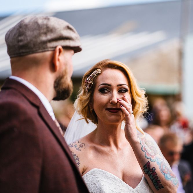 Wedding Ceremony | Bride in Strapless Sassi Holford Wedding Dress with Sweetheart Neckline | Groom in Burgundy Tweed Three Piece Suit | Edison Bulb Floral Installation at Kingsthorpe Lodge Barn Wedding | Johnny Dent Photography