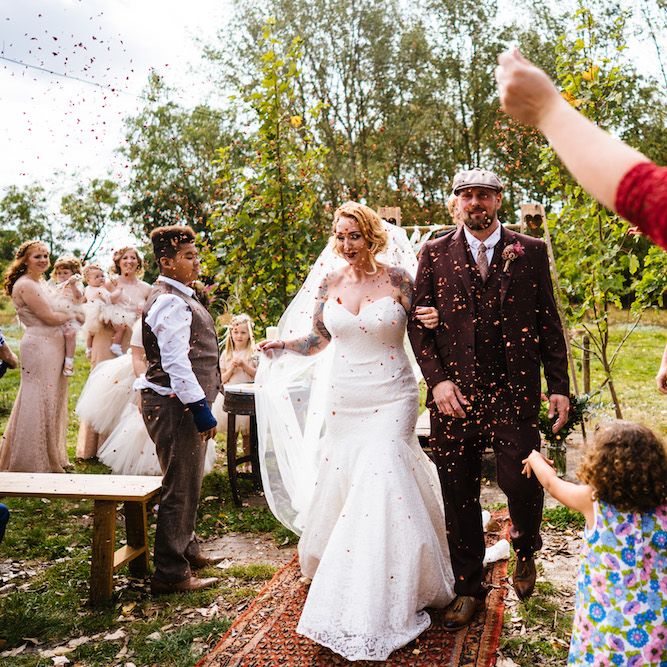 Confetti Moment | Bride in Strapless Sassi Holford Wedding Dress with Sweetheart Neckline | Groom in Burgundy Tweed Three Piece Suit | Edison Bulb Floral Installation at Kingsthorpe Lodge Barn Wedding | Johnny Dent Photography