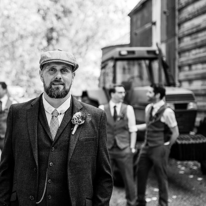 Groom in Burgundy Tweed Three Piece Suit | Groomsmen in Moss Bros. Baker Boy Suits | Edison Bulb Floral Installation at Kingsthorpe Lodge Barn Wedding | Johnny Dent Photography