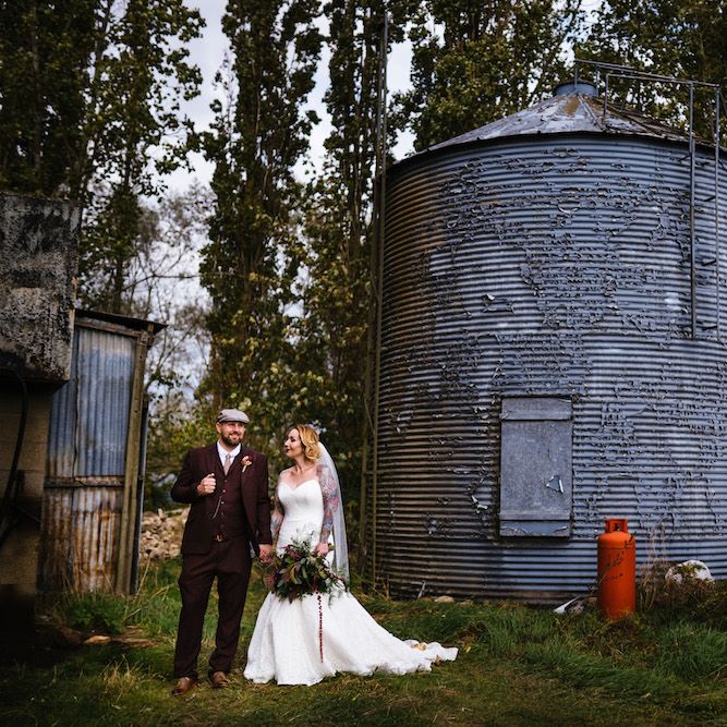 Bride in Strapless Sassi Holford Wedding Dress with Sweetheart Neckline | Groom in Burgundy Tweed Three Piece Suit | Edison Bulb Floral Installation at Kingsthorpe Lodge Barn Wedding | Johnny Dent Photography