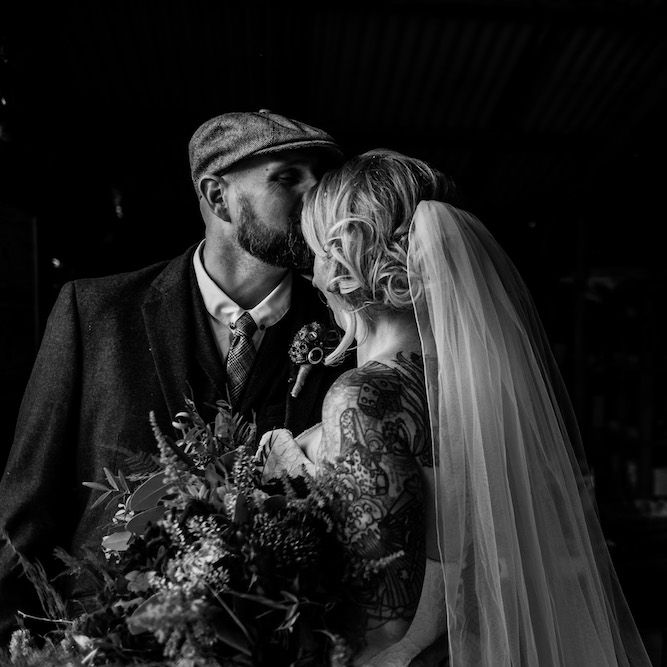 Bride in Strapless Sassi Holford Wedding Dress with Sweetheart Neckline | Groom in Burgundy Tweed Three Piece Suit | Edison Bulb Floral Installation at Kingsthorpe Lodge Barn Wedding | Johnny Dent Photography