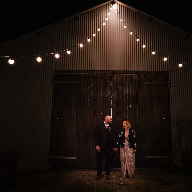 Bride in Sequinned Kimono from ASOS | Groom in Burgundy Tweed Three Piece Suit | Edison Bulb Floral Installation at Kingsthorpe Lodge Barn Wedding | Johnny Dent Photography