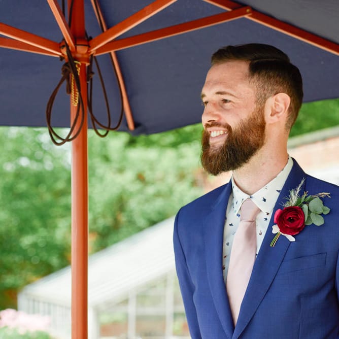Groom In Navy Suit By Paul Smith With Pink Tie