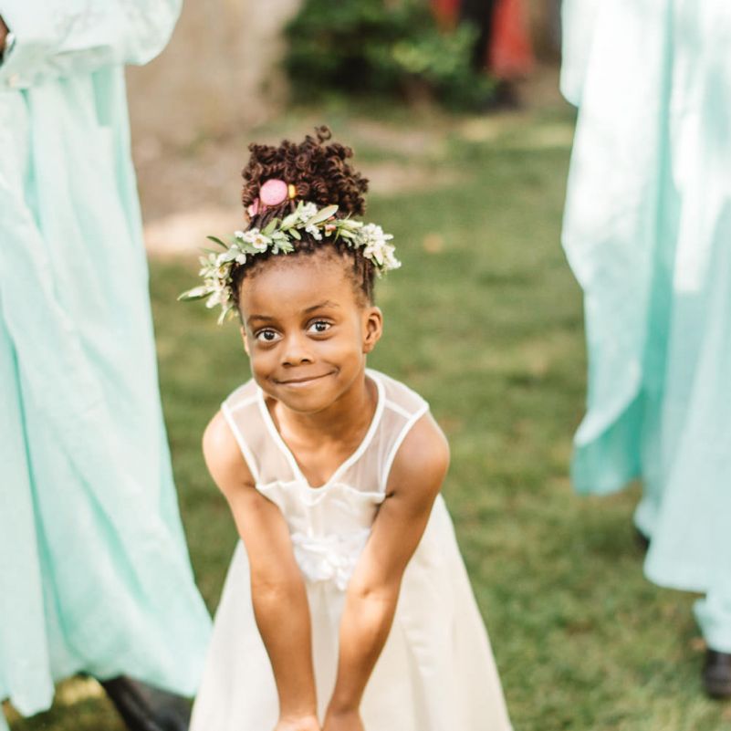 Flower girl in white dress with foliage halo