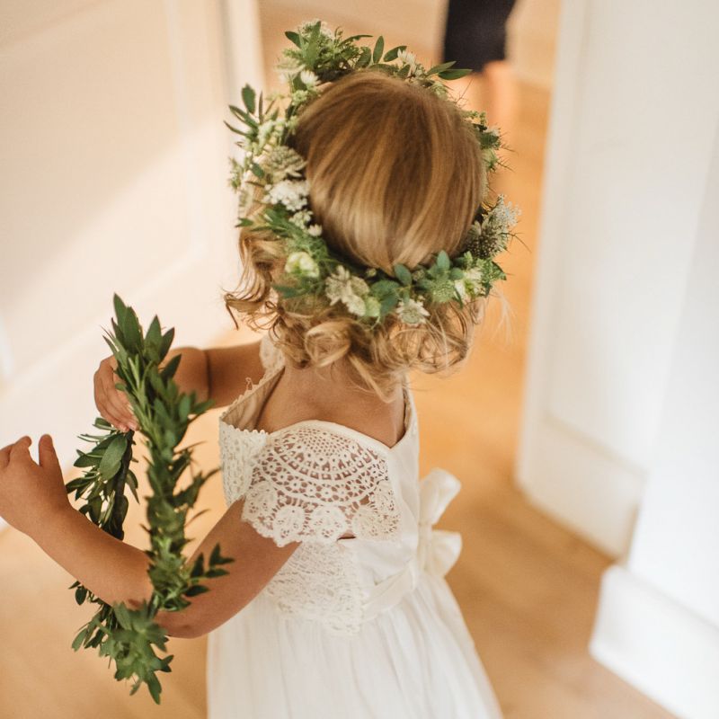 Flower girl in white dress with green crown