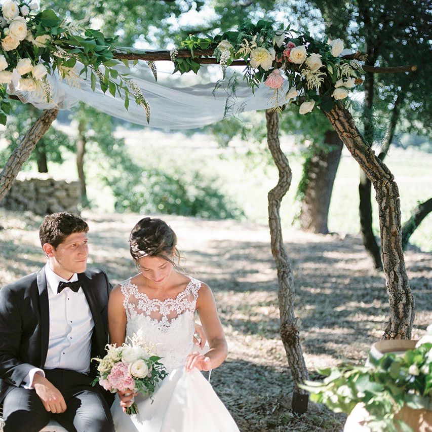 Floral Arch | Elegant Bride in Lace Wedding Dress | Groom in Black Tie Suit | Outdoor Wedding at Commanderie de Peyrassol, Provence, France Styled by La Chuchoteuse | Lace Bridal Gown | Black Tie Suit | Rustic Stretch Tent Reception | Raisa Zwart Photography