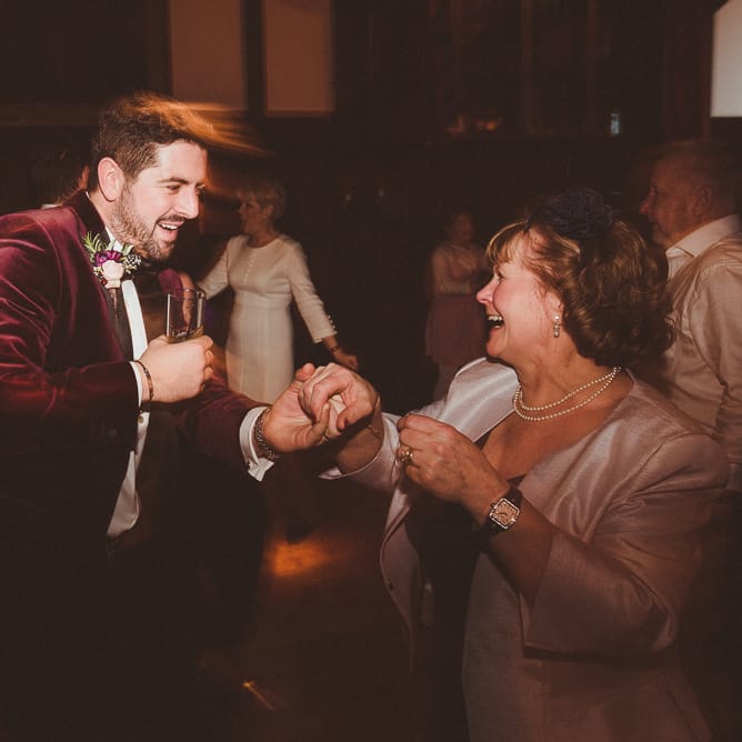 Groom in Velvet Dinner Jacket | Evening Reception Wedding Pictures | Burgundy &amp; Gold Winter Wedding at Ramster Hall Weddings, Surrey | Matt Penberthy Photography | John Harris Wedding Films
