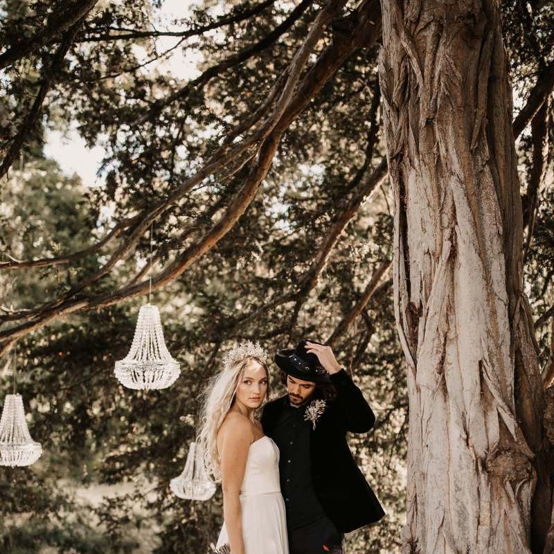 Bride and groom standing under chandeliers