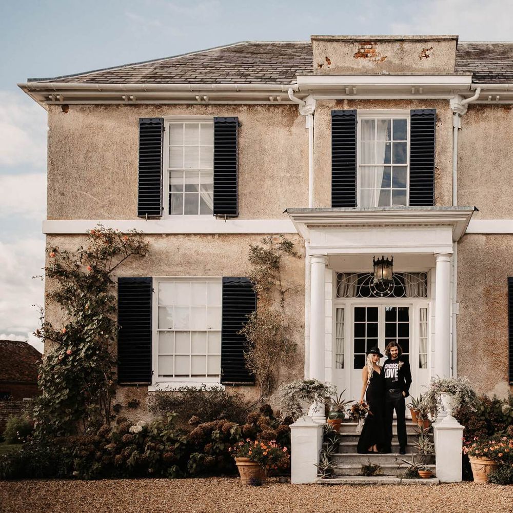 Alternative bride and groom standing outside Preston Court wedding venue