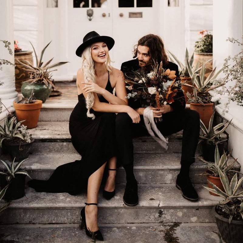 Bride and groom sitting on the steps at Preston Court at Autumn wedding