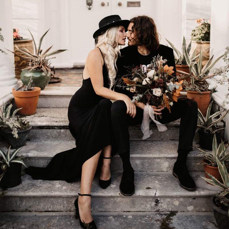Groom in black velvet blazer holding a autumn wedding bouquet at Preston Court