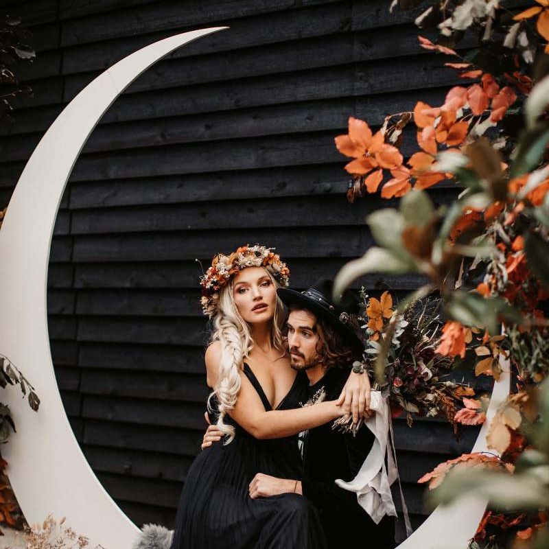 Bride sitting on her grooms lap at Halloween wedding