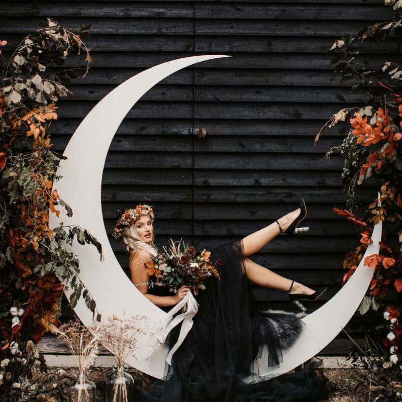 Bride in black wedding dress with orange flower crown and bouquet