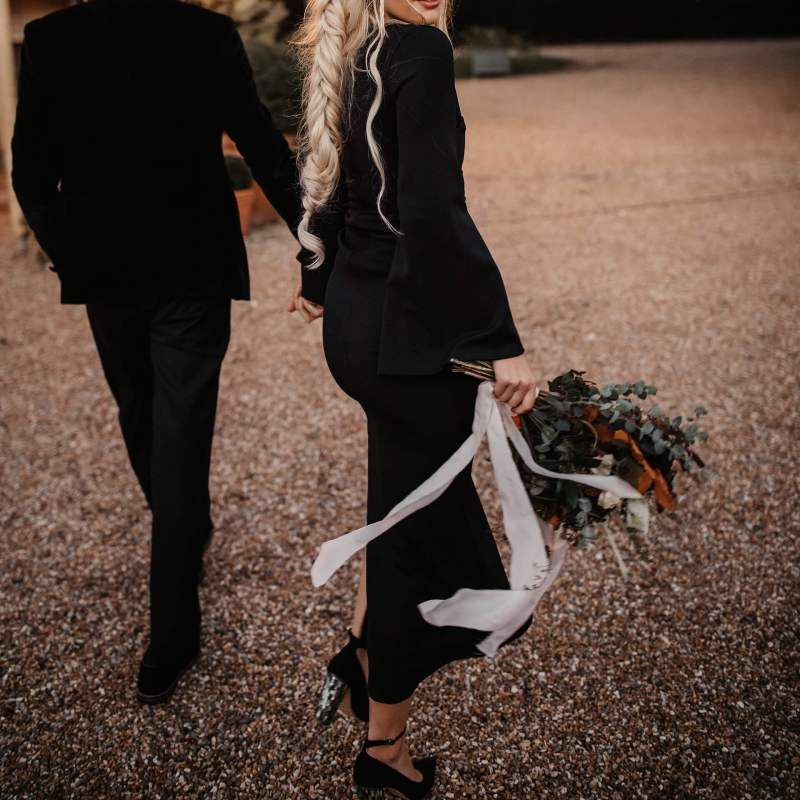 Stylish bride in black wedding dress and orange flower crown