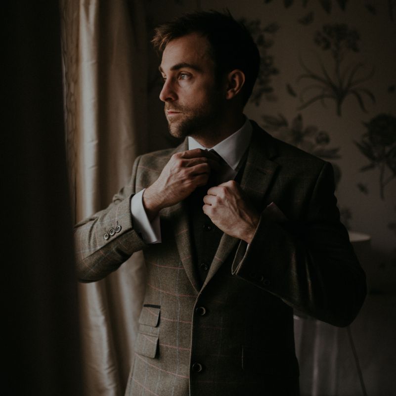 Groom in brown check suit on the wedding morning