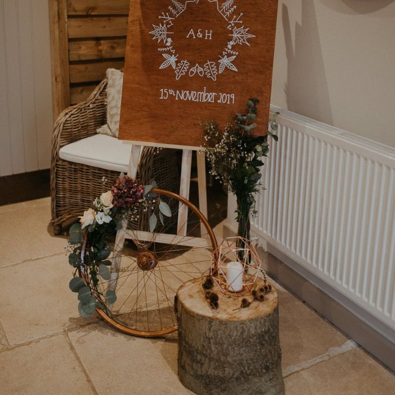 Wooden wedding welcome sign and rustic decor at Lapstone Barn