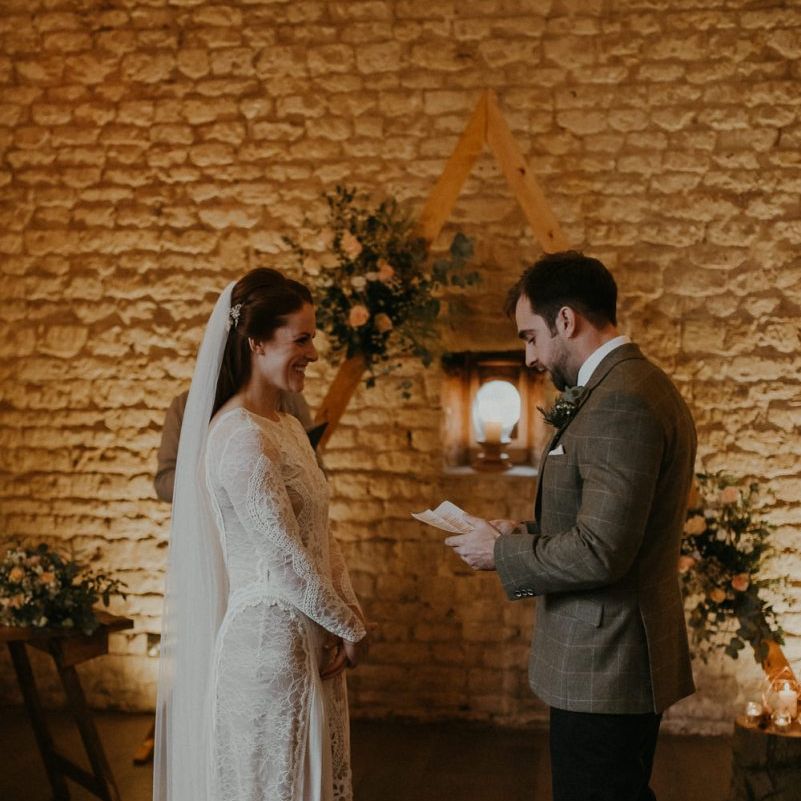 Bride and groom exchanging vows at barn wedding ceremony