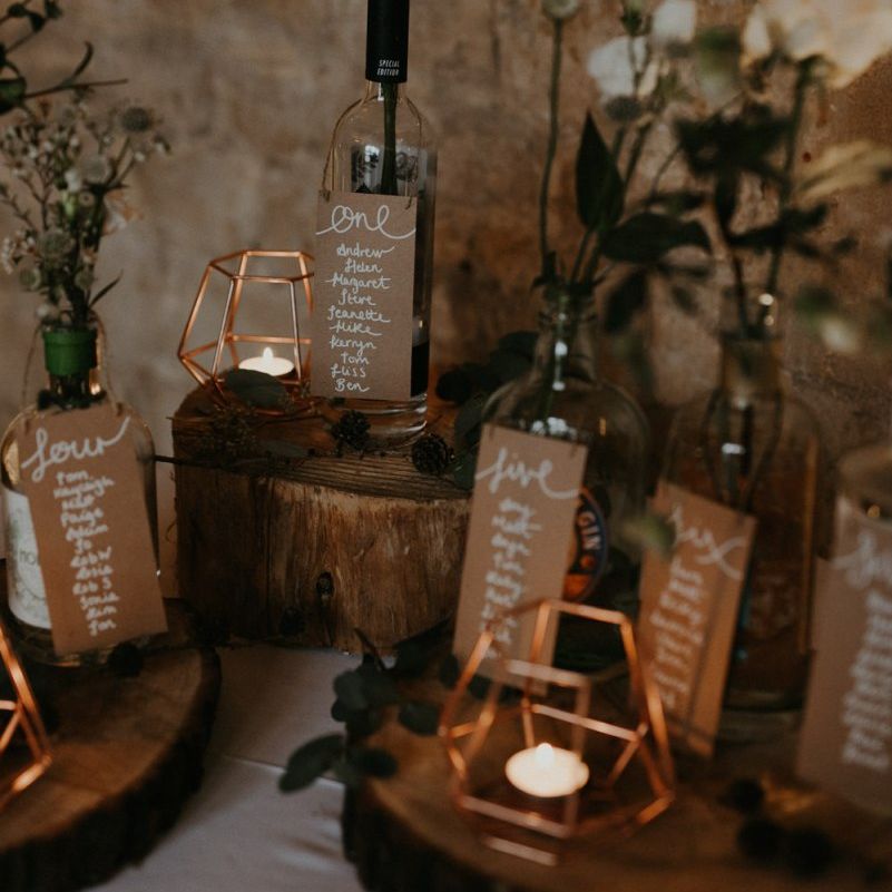 Rustic table plan with tree slices, bottles and terrariums