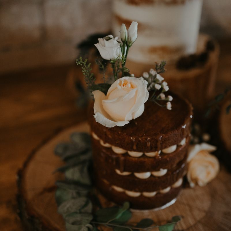 Individual chocolate wedding cake on tree slice with flower decor