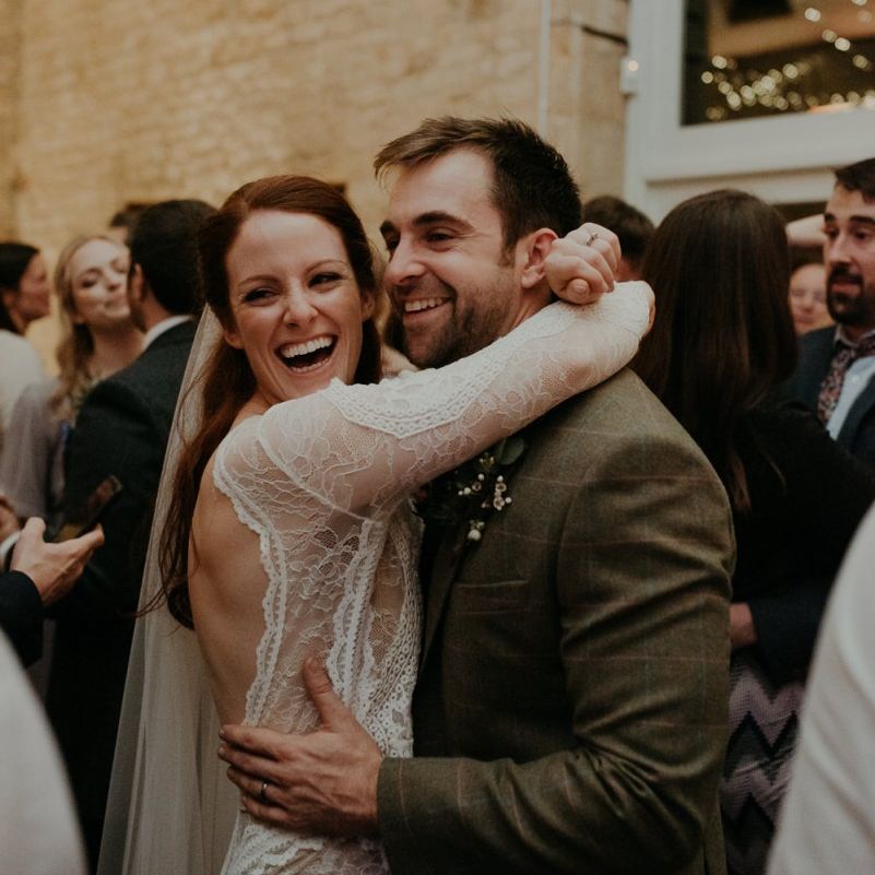 Bride and groom embracing and laughing on the dance floor at Lapstone Barn