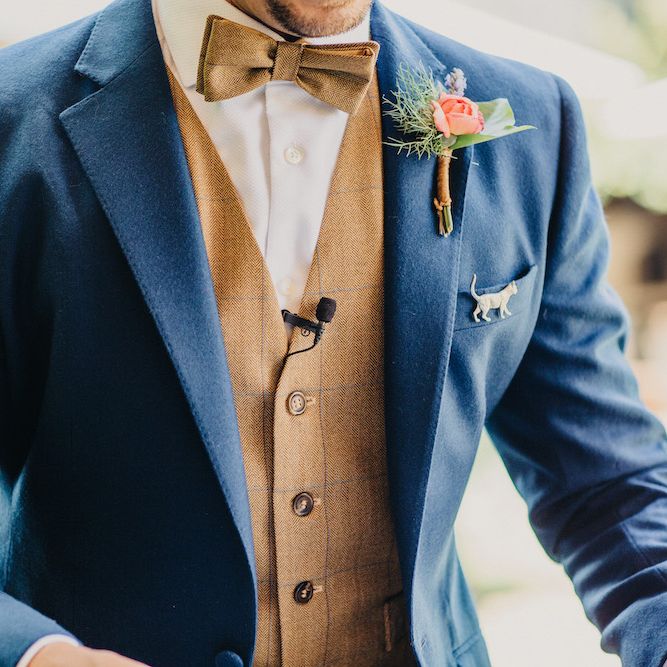 Groom in Blue Two Piece Suit with Tan Waistcoat and Bow Tie | Colourful Bunting Wedding Decor for a Festival Themed Marquee Wedding | Peppermint Love Photography